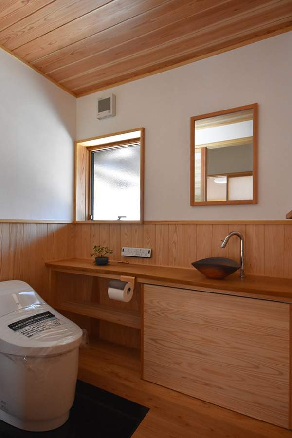 無垢材の板張りと漆喰壁で明るくさわやかなトイレ
